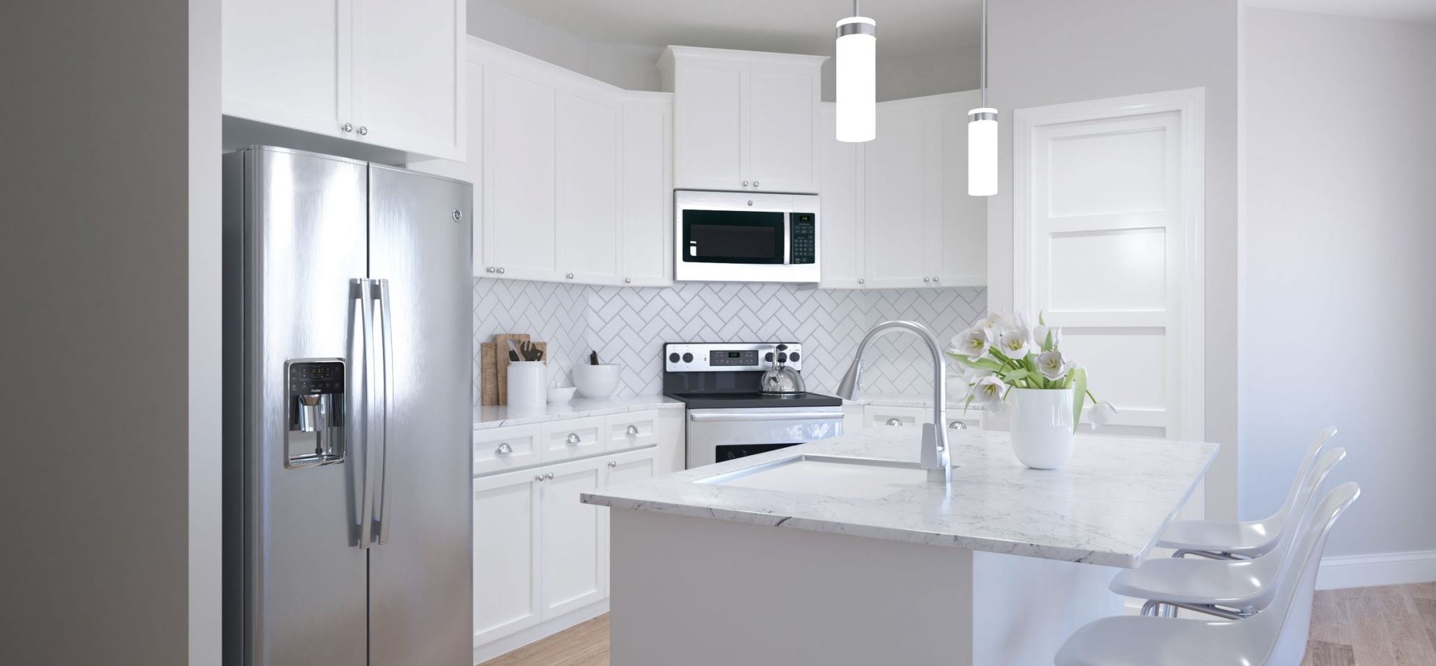 Hawthorne at Traditions apartment kitchen interior with kitchen island, stainless steel appliances, and white cabinetry